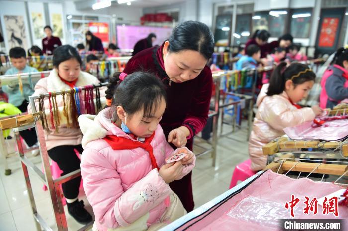 江西省級(jí)非遺豫章繡傳承人手把手指導(dǎo)小學(xué)生繡制2022年北京冬奧會(huì)吉祥物“冰墩墩”形象?！∮髟屏?攝