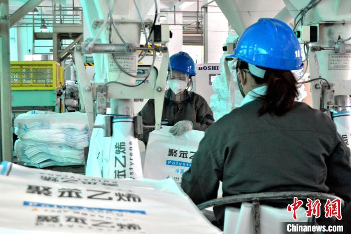 工人在生產(chǎn)線上包裝聚苯乙烯產(chǎn)品?！×趾霔v 攝