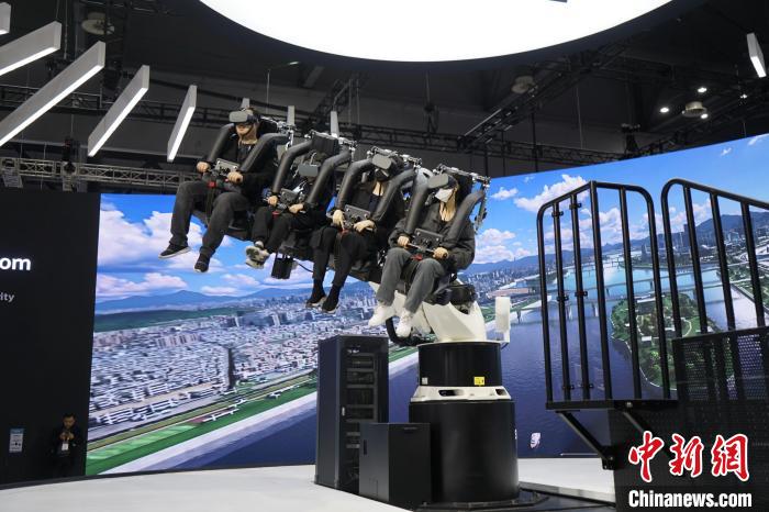 圖為觀眾在展會(huì)模擬體驗(yàn)未來(lái)城市空中移動(dòng)出行方式?！⑿?攝