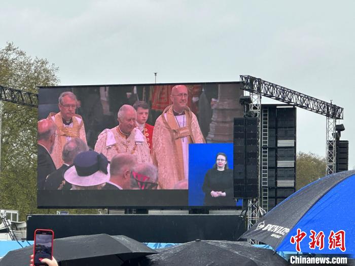 當(dāng)?shù)貢r(shí)間5月6日，英國(guó)國(guó)王查爾斯三世的加冕儀式舉行。民眾雨中觀看儀式。　歐陽(yáng)開(kāi)宇 攝