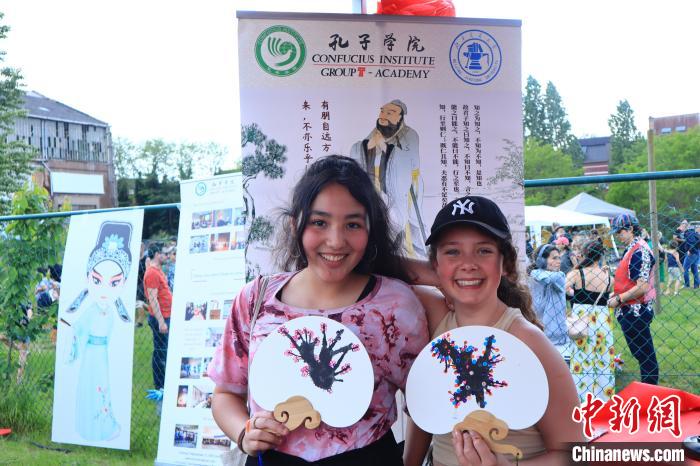 孩子們展示自己的吹墨畫團扇作品?！◆斻肟鬃訉W(xué)院供圖