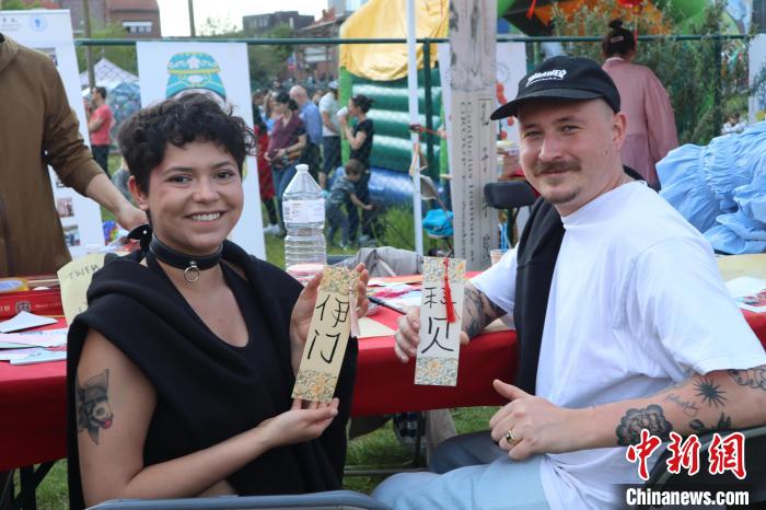 當(dāng)?shù)孛癖娫跐h字體驗工作坊展示自己手寫的中文名書簽?！◆斻肟鬃訉W(xué)院供圖