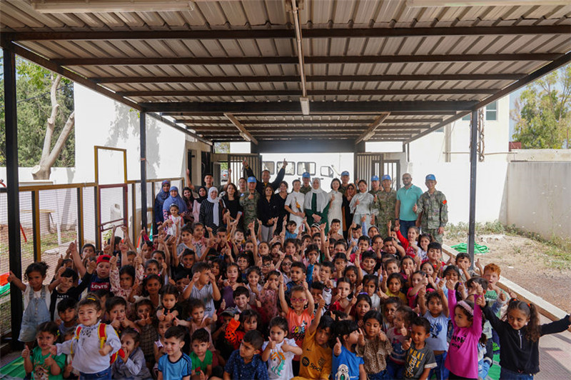 當(dāng)?shù)貢r間5月30日，黎巴嫩南部庫雷拉公立小學(xué)，“六一”國際兒童節(jié)前夕，中國第21批赴黎維和多功能工兵分隊官兵看望慰問學(xué)校師生，并開展文化交流活動，圖為我維和官兵同師生合影。李竹林?jǐn)z