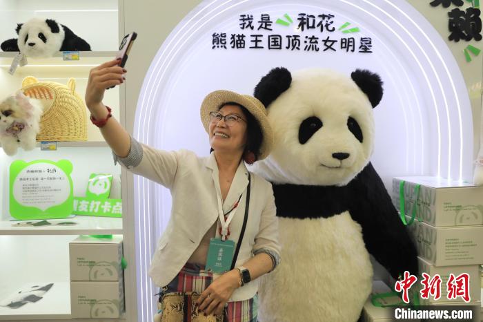 美國(guó)華視總裁楊蓮花與大熊貓文創(chuàng)產(chǎn)品合影?！⊥趵?攝