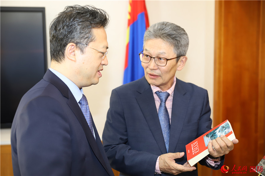 其米德策耶（右一）向李峙介紹翻譯成果。人民網(wǎng)記者 霍文攝