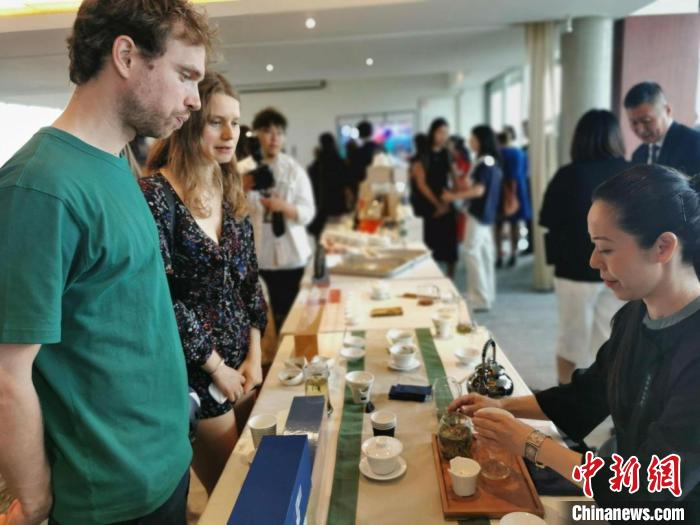 現(xiàn)場觀眾觀看中國展臺(tái)茶藝表演、了解茶文化。　靖樹 攝