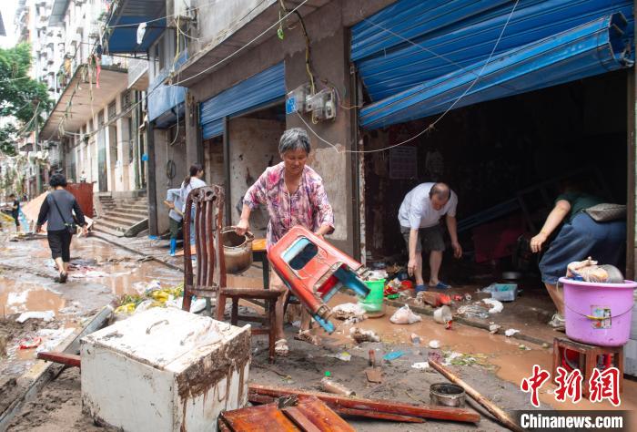 7月4日，萬州區(qū)五橋街道，洪水退去后，居民搶救生活物資?！∪矫宪?攝