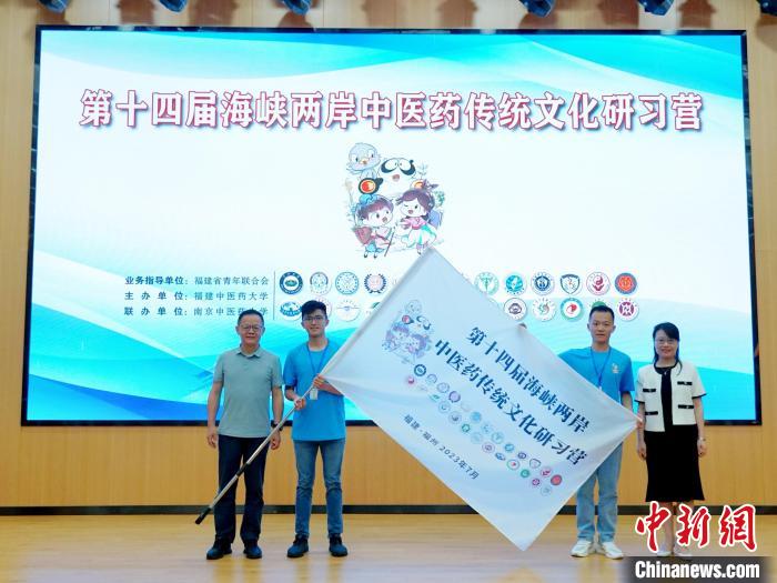 共青團(tuán)福建省委副書(shū)記吳雪(右一)、福建中醫(yī)藥大學(xué)黨委副書(shū)記林羽(左一)為兩岸學(xué)生代表頒授營(yíng)旗?！≡S燁婷 攝