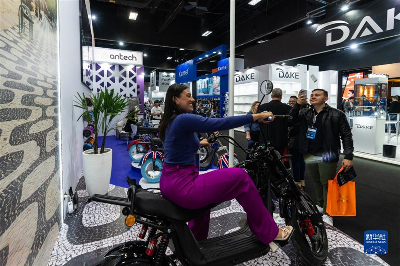 7月10日，在巴西圣保羅舉行的國(guó)際消費(fèi)類電子及家用電器產(chǎn)品展覽會(huì)上，參觀者體驗(yàn)一款電動(dòng)自行車。新華社記者 王天聰 攝