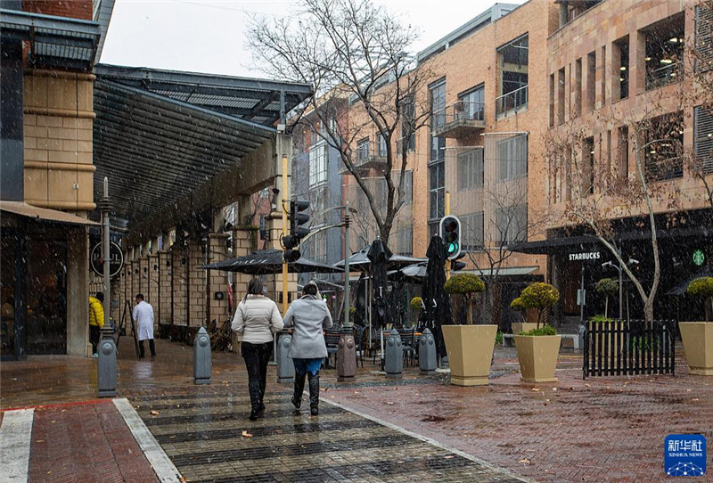 7月10日，在南非約翰內(nèi)斯堡一處商業(yè)區(qū)，人們?cè)谘┲行凶摺Ｐ氯A社記者 張譽(yù)東 攝