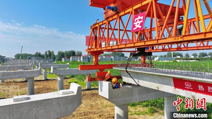 長25米重80噸的箱梁平穩(wěn)、精準地落在S314分離式立交橋25號和26號墩上?！⒂癫?攝