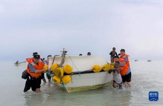 7月21日，中國海軍“和平方舟”號醫(yī)院船醫(yī)護人員涉水登島，前往基里巴斯一診療點。新華社記者 黎云 攝