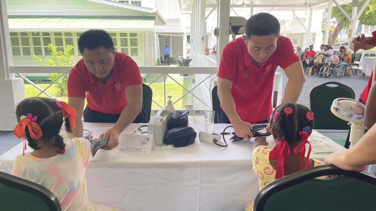 醫(yī)療隊(duì)員為福利院兒童進(jìn)行檢查。第18期援圭亞那醫(yī)療隊(duì)供圖