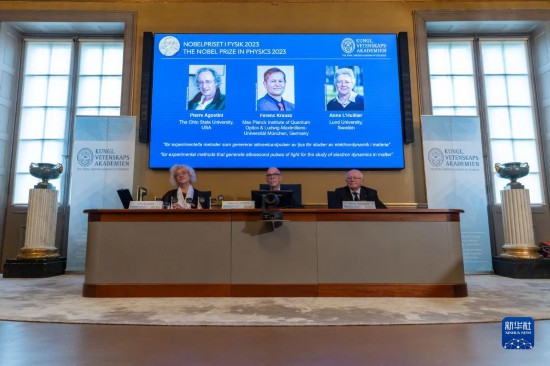 10月3日，在瑞典斯德哥爾摩舉行的2023年諾貝爾物理學獎公布現(xiàn)場，屏幕上顯示獎項得主皮埃爾·阿戈斯蒂尼（左）、費倫茨·克勞斯（中）和安妮·呂利耶的照片。新華社發(fā)（魏學超攝）