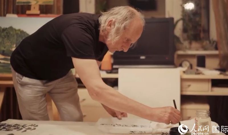 伊戈?duì)枴げ紶枛|諾夫在畫(huà)作上題詞。人民網(wǎng)記者 馬天翼攝