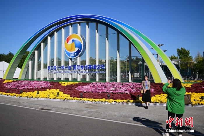 10月15日，北京，工作人員在國(guó)家會(huì)議中心外的第三屆“一帶一路”國(guó)際合作高峰論壇景觀布置前拍照留念。當(dāng)日，位于國(guó)家會(huì)議中心的第三屆“一帶一路”國(guó)際合作高峰論壇新聞中心啟動(dòng)試運(yùn)行。據(jù)悉，第三屆“一帶一路”國(guó)際合作高峰論壇將于10月17日至18日在北京舉行。<a target='_blank' href='/'><p  align=