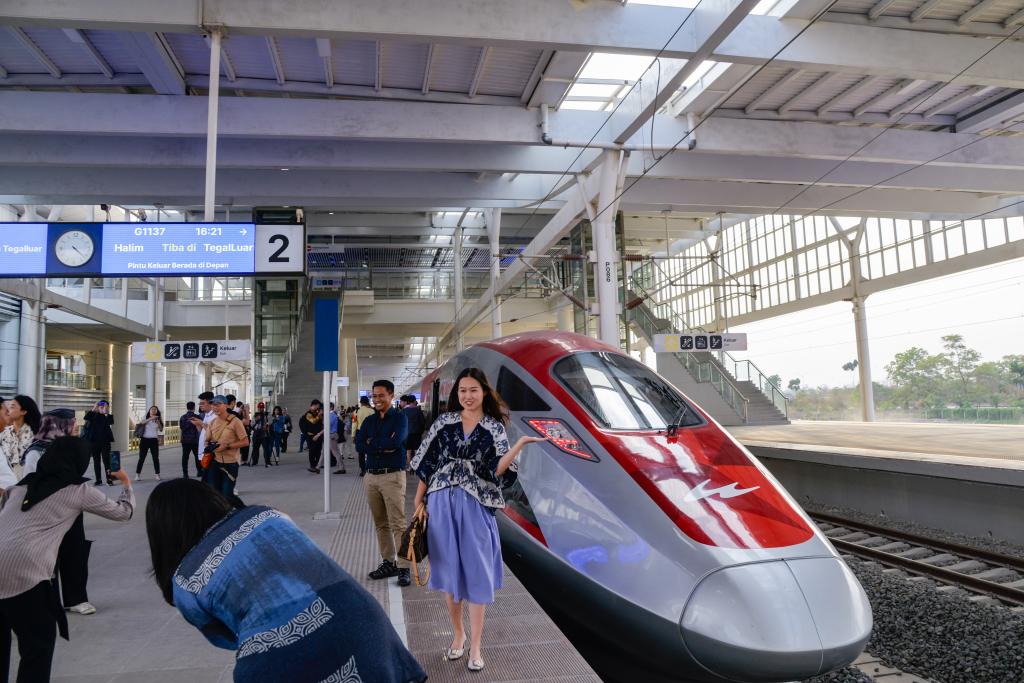 10月17日，在印度尼西亞萬隆德卡魯爾站，乘客在站臺上和雅萬高鐵高速動車組列車合影。