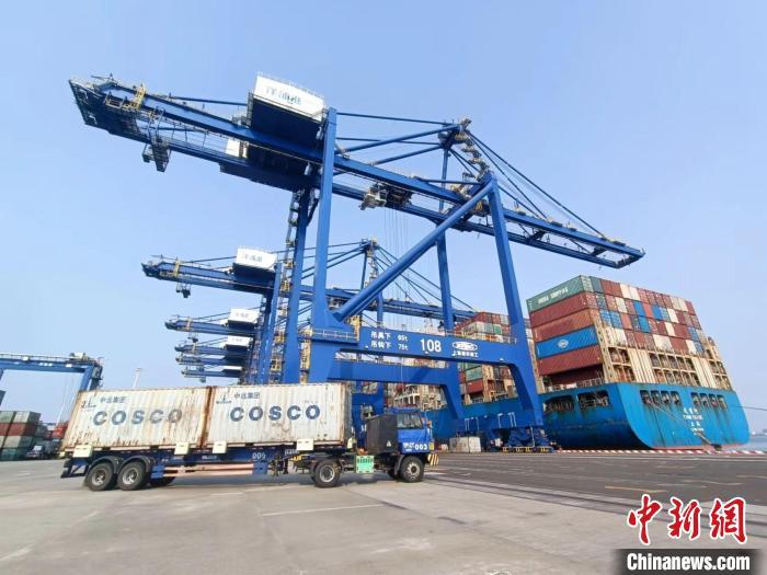 圖為海南洋浦國際集裝箱碼頭，卡車將集裝箱從后方堆場運往碼頭裝卸區(qū)?！堅潞?攝