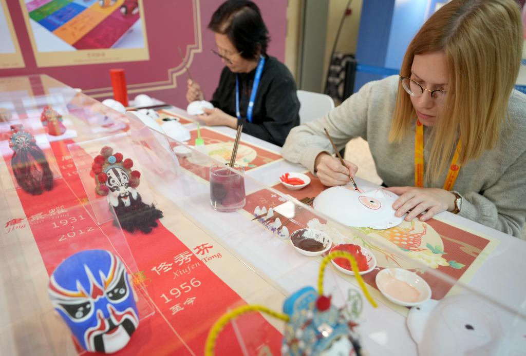 10月16日，在第三屆“一帶一路”國(guó)際合作高峰論壇新聞中心，來(lái)自比利時(shí)的記者（右）體驗(yàn)畫(huà)京劇臉譜。新華社記者 王毓國(guó) 攝