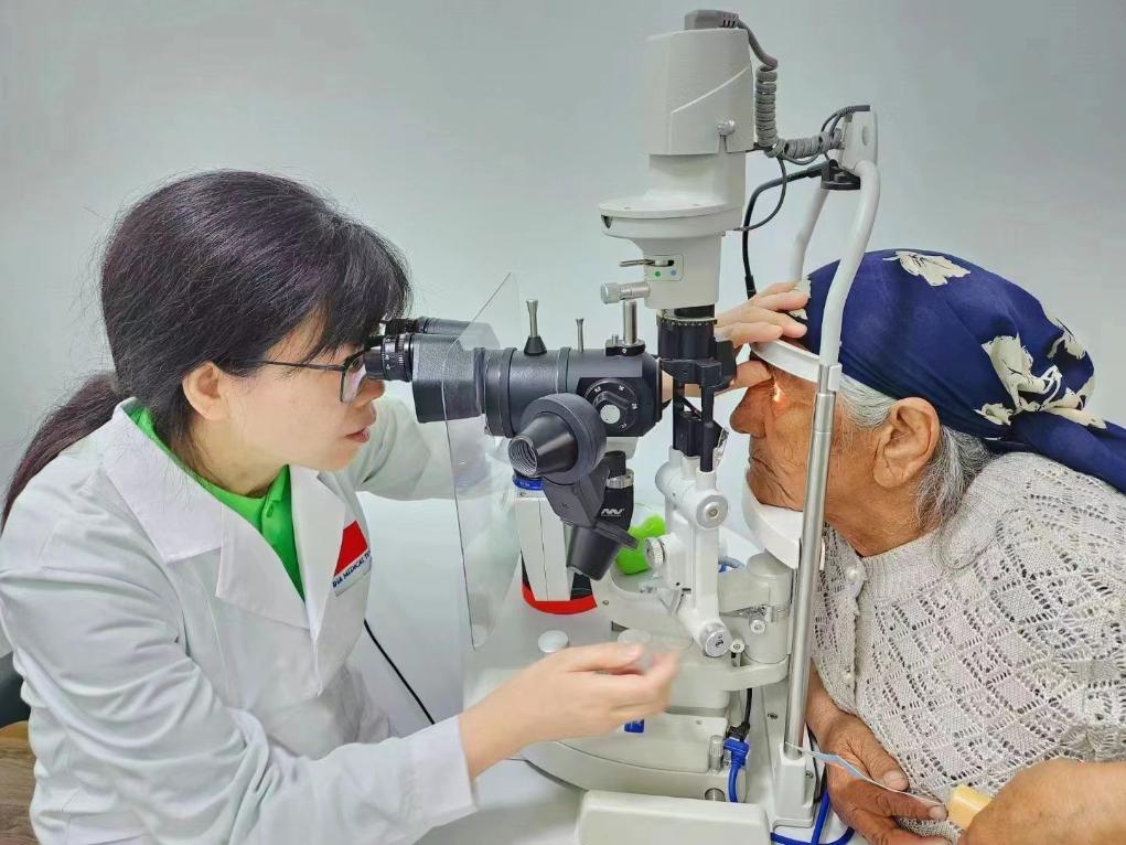 北京大學(xué)人民醫(yī)院眼科醫(yī)生鮑永珍正在為中亞白內(nèi)障患者進(jìn)行眼部檢查。（北京大學(xué)人民醫(yī)院供圖）