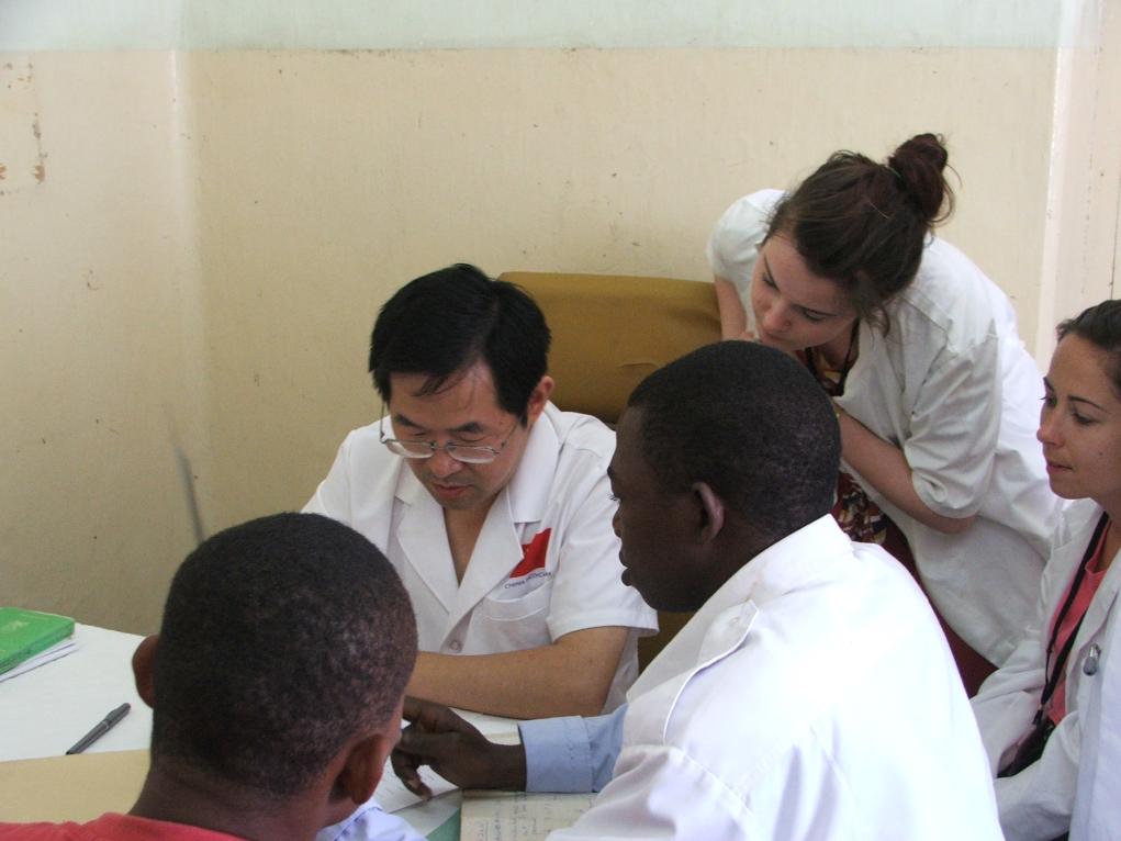 2011年7月22日，在坦桑尼亞桑給巴爾納茲莫加醫(yī)院外科門(mén)診，中國(guó)第24批援桑給巴爾醫(yī)療隊(duì)隊(duì)長(zhǎng)盧建林為當(dāng)?shù)鼗颊咴\治并帶教實(shí)習(xí)生。新華社發(fā)（國(guó)家衛(wèi)生健康委供圖）