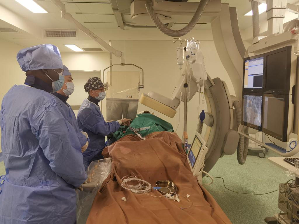 中國(guó)第29批援幾內(nèi)亞醫(yī)療隊(duì)隊(duì)員、首都醫(yī)科大學(xué)附屬北京天壇醫(yī)院心內(nèi)科副主任醫(yī)師王汝朋（右一）正在給患者做手術(shù)。（北京天壇醫(yī)院供圖）