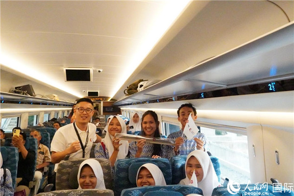 第一次乘坐雅萬高鐵動車組的學(xué)生們與動車組模型合影。人民網(wǎng)記者曹師韻攝