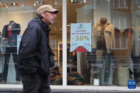   10月31日，一名男子從比利時(shí)布魯塞爾一家貼有打折信息的店鋪前走過(guò)。新華社記者 趙丁喆 攝