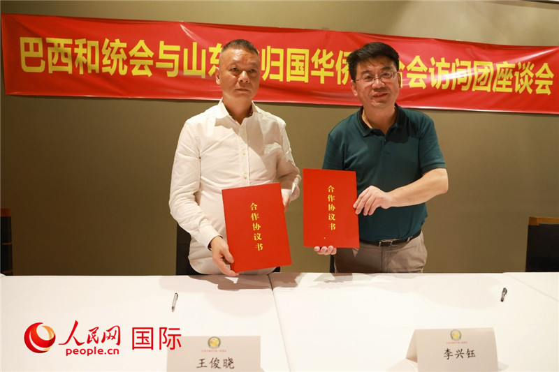 中國僑聯(lián)副主席、山東省僑聯(lián)主席李興鈺（右）與巴西和統(tǒng)會(huì)會(huì)長王俊曉簽署合作協(xié)議書。人民網(wǎng)記者 陳海琪攝