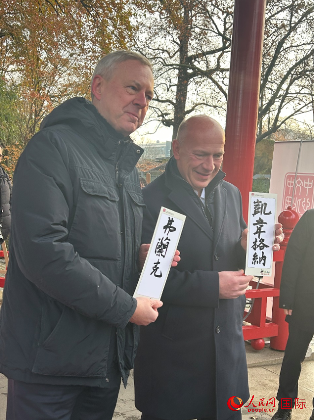 柏林市長韋格納（右）、動(dòng)物園監(jiān)事會(huì)主席布魯克曼（左）手持中國文化中心工作人員現(xiàn)場手書的中文名字。人民網(wǎng)記者 徐馨攝