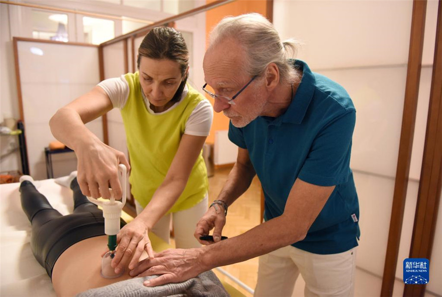 12月12日，在奧地利維也納，科格勒醫(yī)生（右）和助手在為病人進(jìn)行拔罐治療。新華社記者 賀燦鈴 攝