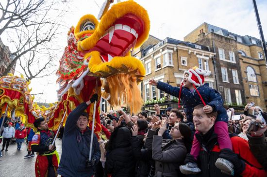 2月11日，人們在英國倫敦的新春巡游活動中觀看舞龍表演。新華社發(fā)（史蒂芬·程攝）