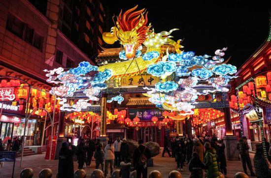 2月11日，游客在沈陽中街游覽。春節(jié)期間，各地?zé)艋痂病⒒饦溷y花，呈現(xiàn)出一幕幕流光溢彩的視覺盛宴。（新華社記者潘昱龍攝）