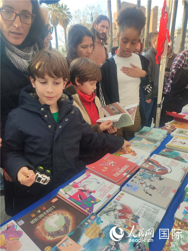 印刷精美的中國(guó)傳統(tǒng)文化叢書吸引了小游客的注意。人民網(wǎng)記者鄭彬攝