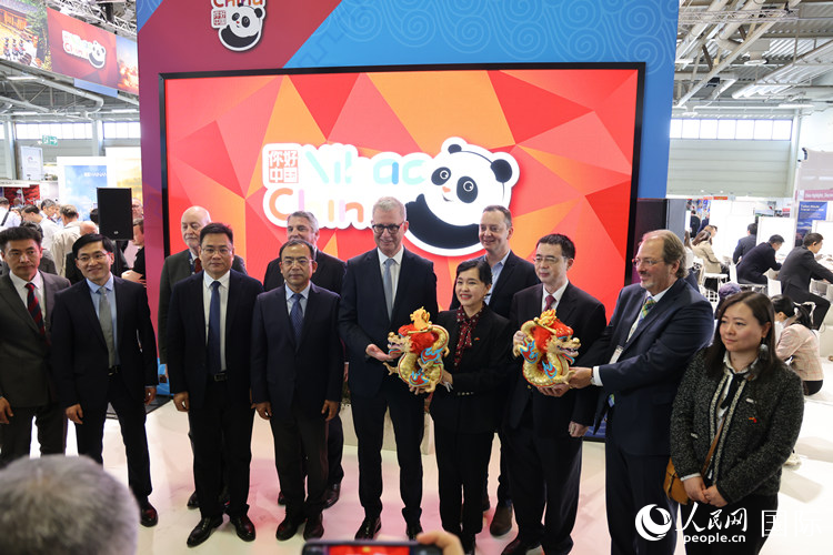 參加中國館開幕式的嘉賓們在“你好 中國” 展臺前合影留念。