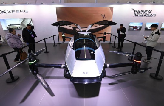 2023年12月1日，在鏈博會智能汽車鏈展區(qū)小鵬汽車展臺，參觀者觀看一臺智能飛行器。新華社記者蔡湘鑫攝