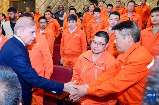 4月1日，在巴基斯坦西北部開伯爾-普什圖省達蘇，巴基斯坦總理夏巴茲（左）同達蘇水電站項目中方員工握手。新華社發(fā)（巴基斯坦新聞與廣播部下轄媒體信息部門供圖）