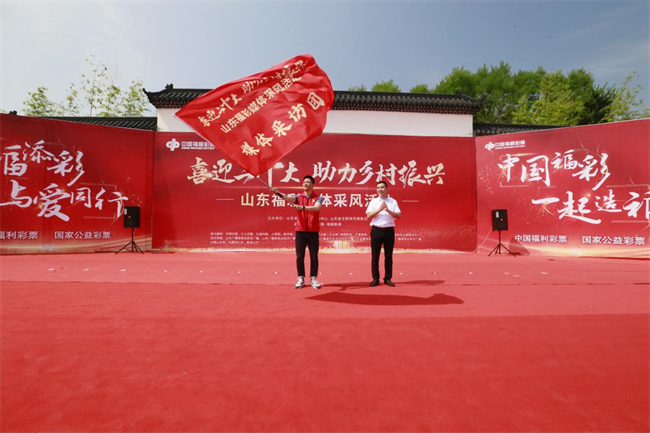為媒體采風(fēng)團授旗。 山東省福彩供圖