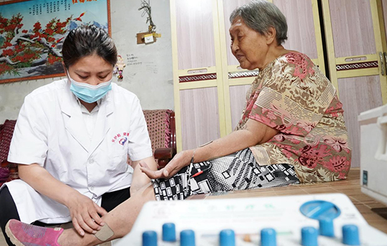 護理團隊醫(yī)生為老人進行低頻功能康復。陳佳兵攝