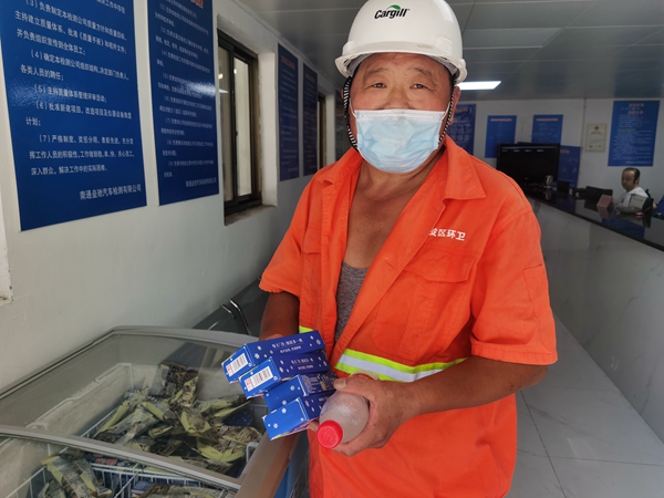 1環(huán)衛(wèi)工倪建宏小憩后，為還同事帶去冷飲。人民網(wǎng)記者王繼亮攝