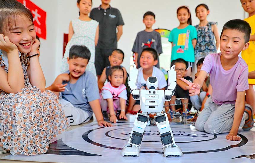 2022年7月19日，河北省秦皇島市海港區(qū)白塔嶺街道秦皇半島第二社區(qū)內(nèi)，小朋友正在觀看“機(jī)器人跳舞”。 曹建雄攝