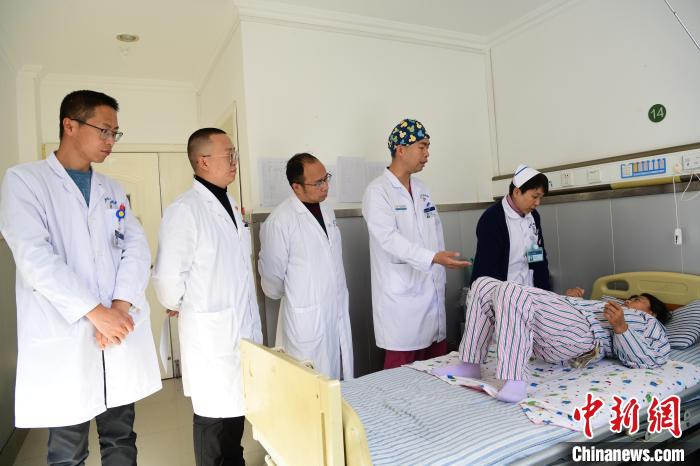 圖為何蔚副主任醫(yī)師(站右二)及團隊術后指導患者進行腰背肌鍛煉?！∝暩聛硭?攝