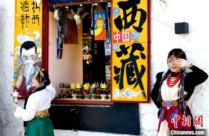 4月17日，游客身著藏式元素服裝在拉薩八廓街拍照留念?！±盍?攝