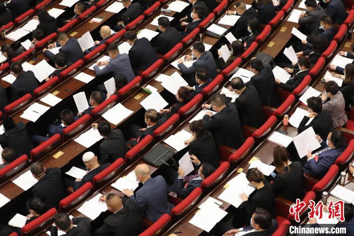 圖為會議現(xiàn)場，參會代表正在聽取政府工作報告?！∑钤鲚?攝