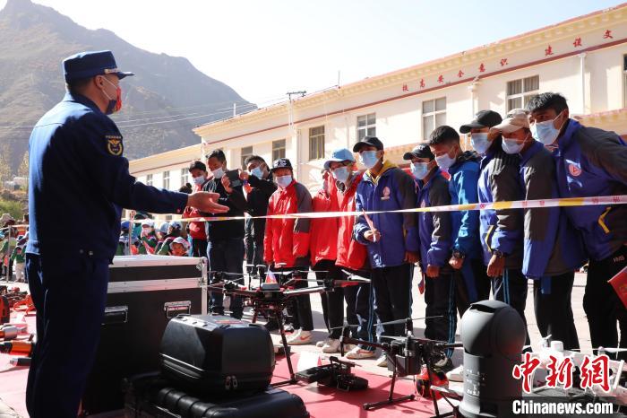 圖為消防指戰(zhàn)員為學生講解、演示先進救援裝備?！≮w琳 攝