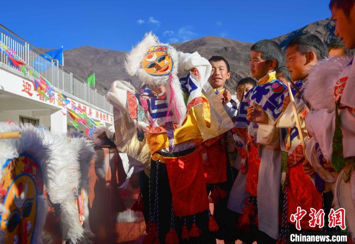 圖為加查縣安繞鎮(zhèn)小學學生在試穿藏戲面具?！∝暩聛硭?攝