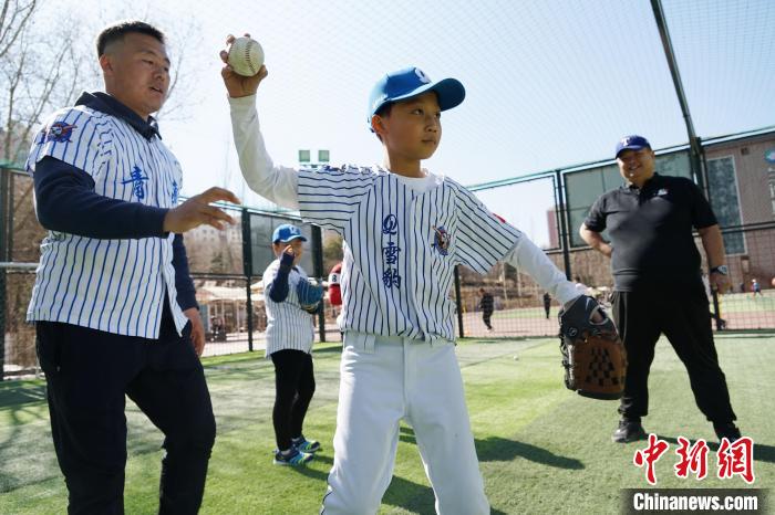 圖為教練指導(dǎo)小棒球手?jǐn)S球技術(shù)?！●R銘言 攝