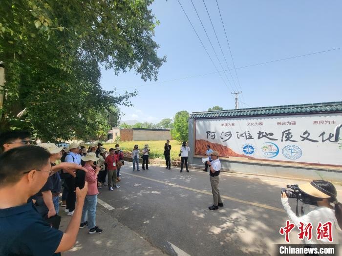 圖為中國地質(zhì)大學(xué)(北京)教授張緒教介紹村落情況。　胡友軍 攝