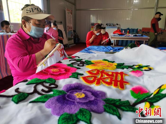 圖為婦女制作青繡?！?zhí)砀?攝