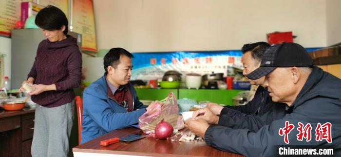 圖為扶貧路上“臨時(shí)一家人”準(zhǔn)備午餐?！∥航ㄜ?攝